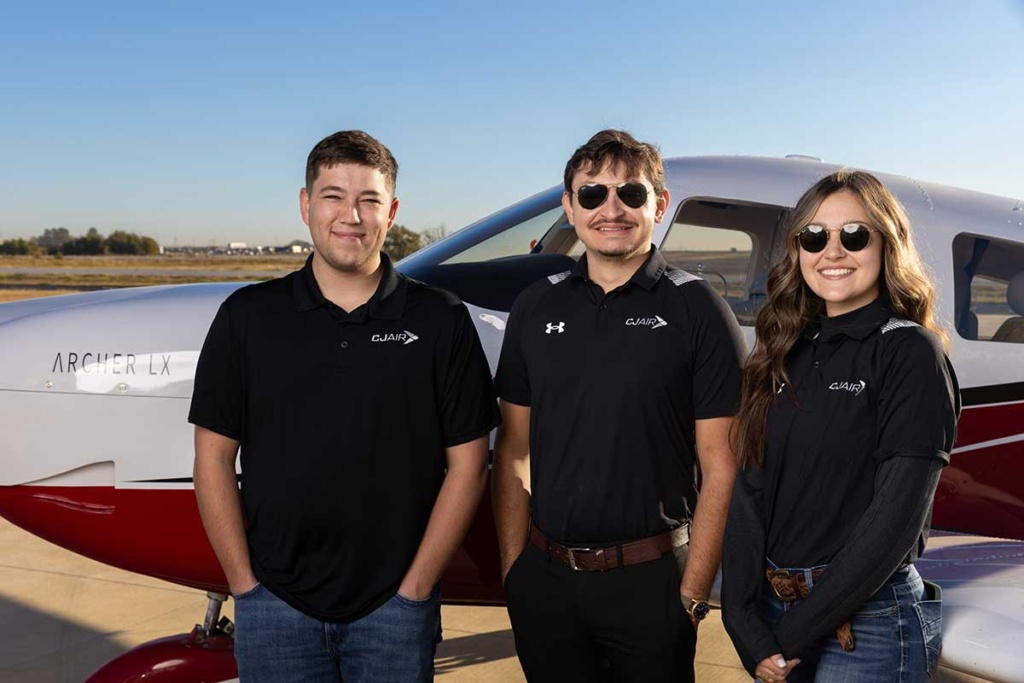 Group of CJ Air flight instructors in front of an airplane